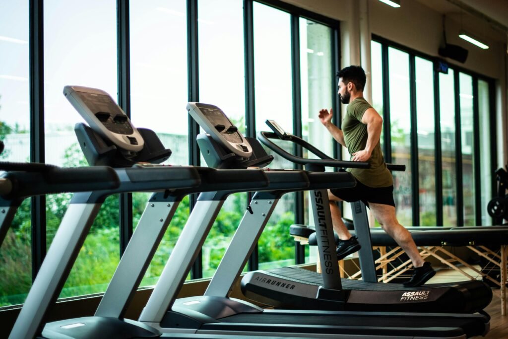 pexels-photo-1954524-1954524 Young man workouts on treadmill in modern gym with large windows and natural light.