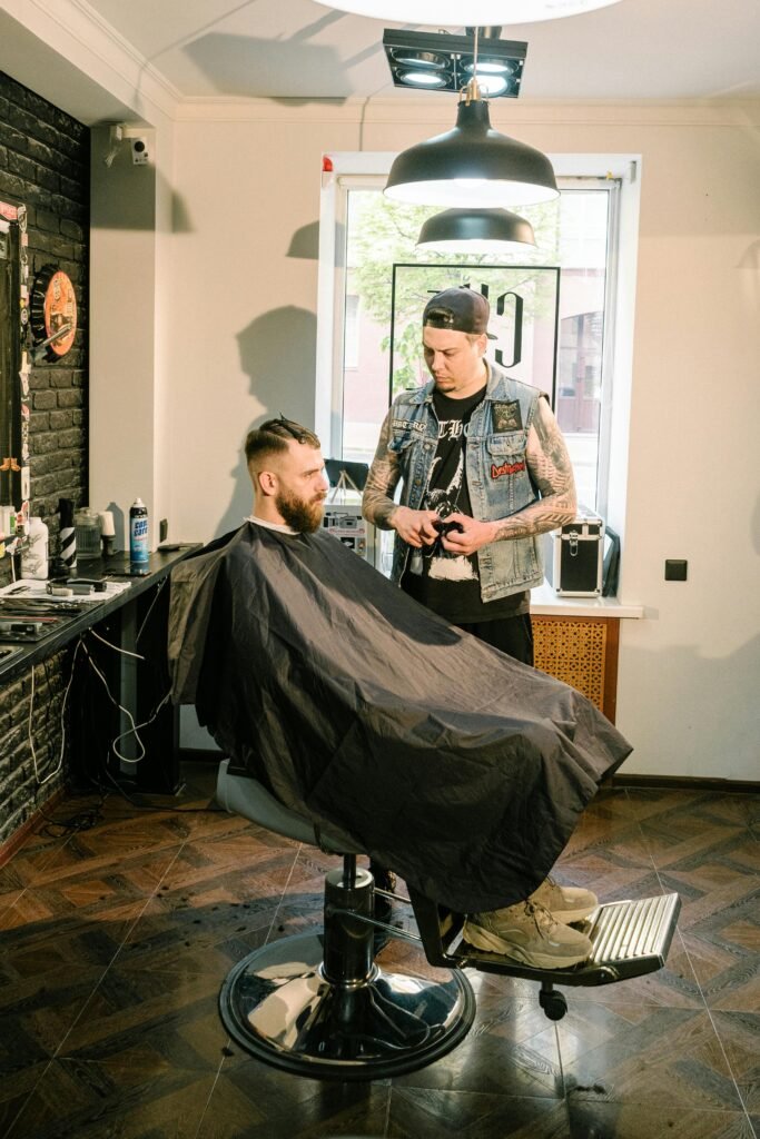 pexels-photo-4625616-4625616 A tattooed barber styling a client's hair in a trendy salon setting.