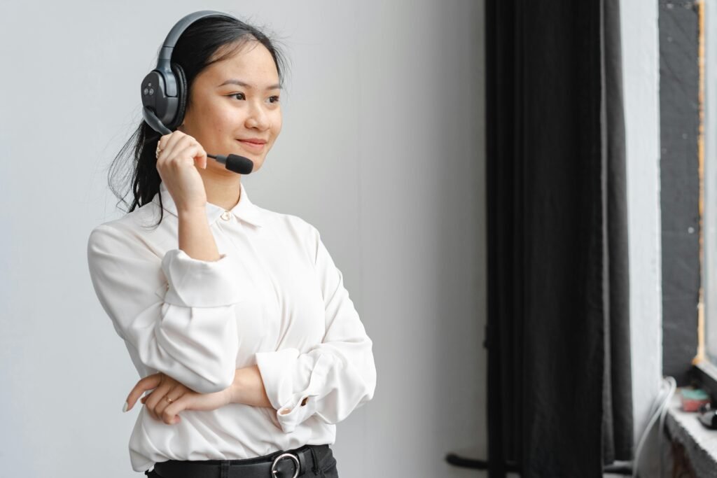 pexels-photo-7682355-7682355 Professional Asian woman with headset providing customer support in an office setting.